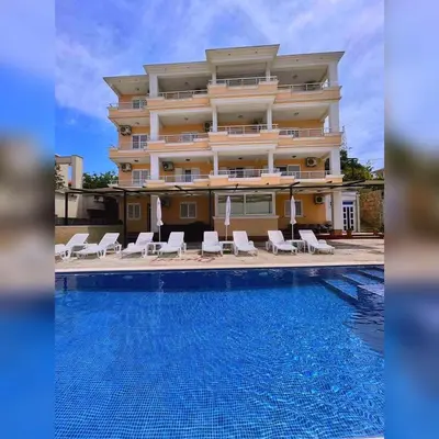 a hotel with a swimming pool in front of a building at Queen Kodre Apartments in Ulcinj