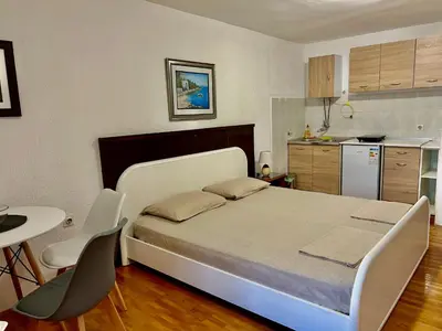 a bedroom with a bed and a table and chairs at Apartments Jankovic in Podgorica