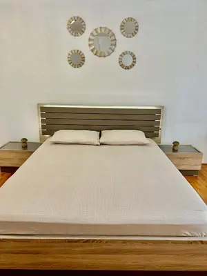 a bedroom with a bed with three clocks on the wall at Apartments Jankovic in Podgorica