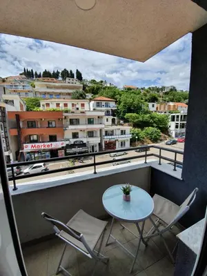 a balcony with a table and chairs and buildings at Bella Vista B&B in Ulcinj