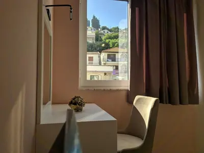a room with a table and a chair and a window at Bella Vista B&B in Ulcinj