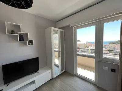 a living room with a flat screen tv and two windows at Bella Vista B&B in Ulcinj