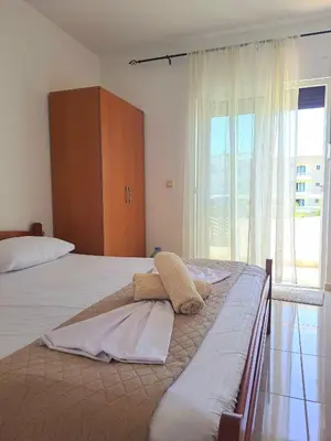 a bedroom with two beds and a large window at Lazorja Rooms in Ulcinj