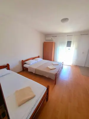 a bedroom with two beds and a wooden floor at Lazorja Rooms in Ulcinj