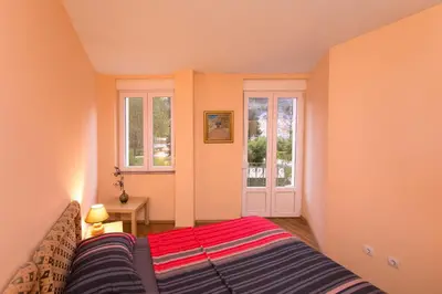 a small room with a bed and a window at Apartments Bokan in Cetinje