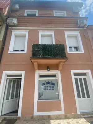 a pink building with a sign in the window at Apartments Bokan in Cetinje