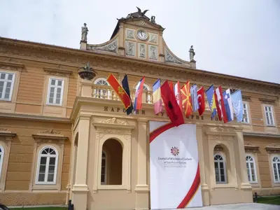 a building with a bunch of flags in front of it at Apartments Bokan in Cetinje