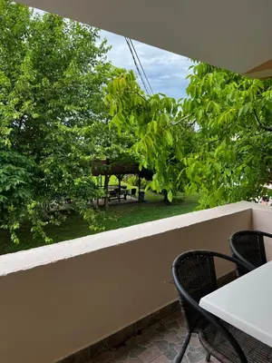 a balcony with a table and chairs and trees at Apartments Rudaj in Ulcinj