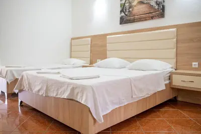 a bedroom with two beds with white sheets at Apartments Rudaj in Ulcinj