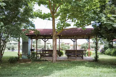 two benches under a gazebo in a park at Apartments Rudaj in Ulcinj