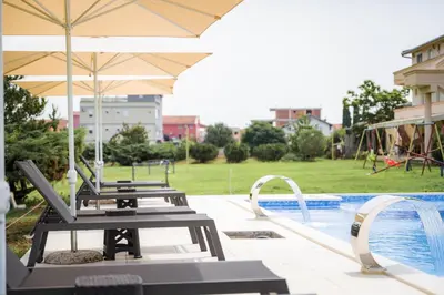 a group of chairs and an umbrella next to a pool at Apartments Rudaj in Ulcinj