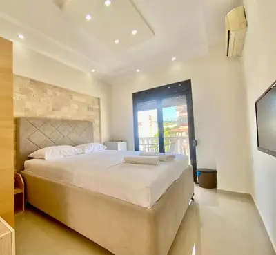 a bedroom with a large bed and a television at Fimi Apartments in Ulcinj