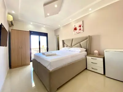 a bedroom with a large bed and a window at Fimi Apartments in Ulcinj