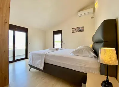 a bedroom with a large bed with white sheets at Fimi Apartments in Ulcinj