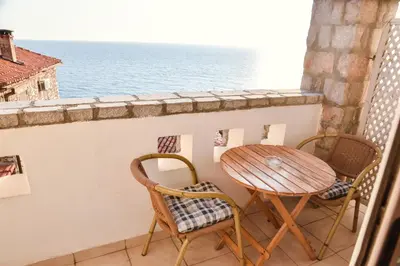 a table and chairs on a balcony overlooking the ocean at Villa Dulcinea in Ulcinj