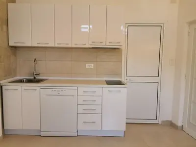 a kitchen with white cabinets and a white refrigerator at House Carpe Diem with the best sea view in Masline
