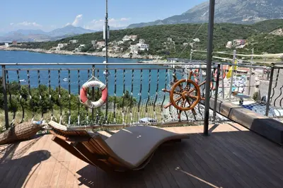 a hammock on a balcony with a view of the water at House Carpe Diem with the best sea view in Masline