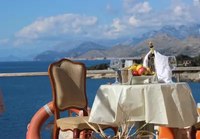 a table with a bowl of fruit and wine glasses at House Carpe Diem with the best sea view in Masline
