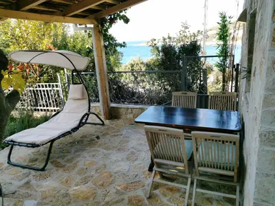 a table and chairs on a patio with the ocean at House Carpe Diem with the best sea view in Masline