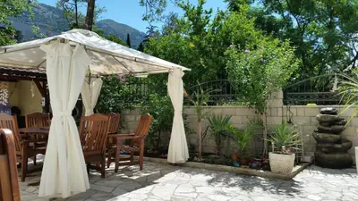 a white umbrella over a table and chairs at Apartments Beba Zalad in Sutomore