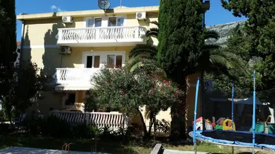 a yellow house with a tree and a swimming pool at Apartments Beba Zalad in Sutomore