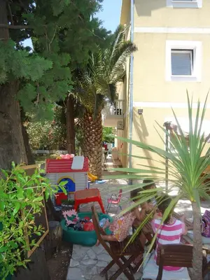 a backyard with chairs and toys on a patio at Apartments Beba Zalad in Sutomore