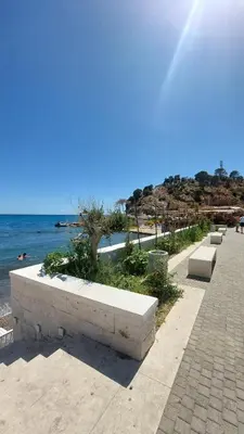 a row of benches on a sidewalk near the beach at Apartments Beba Zalad in Sutomore