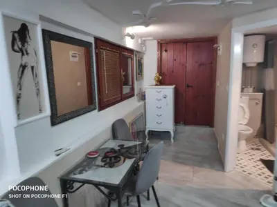 a dining room with a table and a bathroom at Apartman Art in Kotor