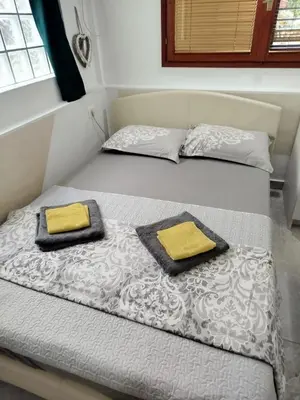 two beds in a room with yellow pillows on them at Apartman Art in Kotor