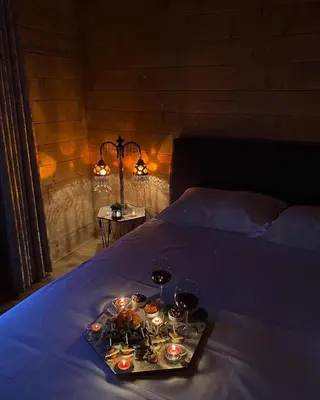a tray of candles and wine glasses on a bed at Ranc Mujica in Bar