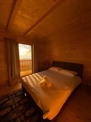 a bed in a wooden room with a window at Ranc Mujica in Bar