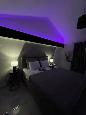 a bedroom with a bed with purple lights on it at Ranc Mujica in Bar