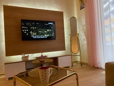 a living room with a table and a tv on the wall at Krizor Apartman Budva in Budva