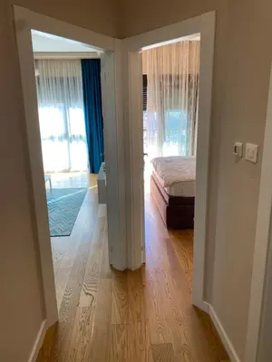 a bedroom with a bed and a door leading into a room at Apartment Sofia, City Centar in Podgorica