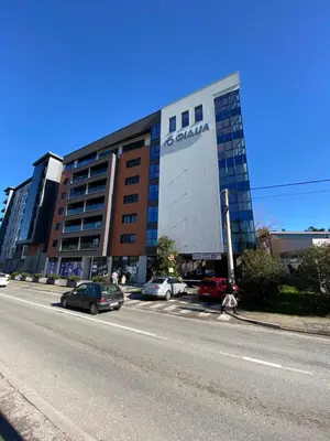 a large building with cars parked in front of it at Apartment Sofia, City Centar in Podgorica