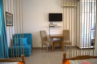 a living room with a blue chair and a table at Yeshill Apart & Studio in Budva
