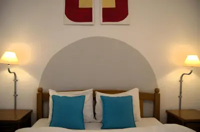 a bedroom with a bed with two blue pillows at Yeshill Apart & Studio in Budva