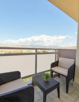 a balcony with two chairs and a table with a view at Design Apartment at CITY QUART in Podgorica