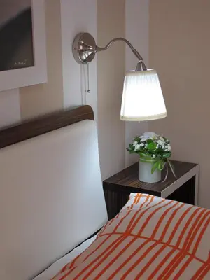 a bedroom with a bed and a lamp and flowers at Apartments Inspiration in Budva