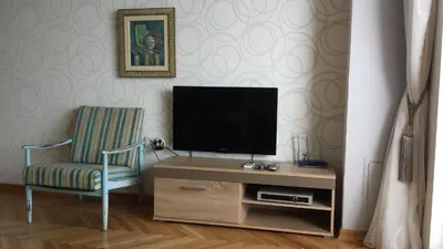 a living room with a tv and a chair at Apartments Inspiration in Budva