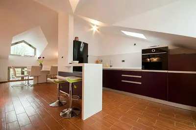 a kitchen with a stove and a counter with a table at Domador Rooms & Apartments in Budva