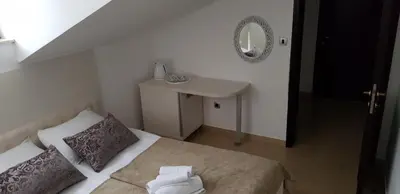 a bedroom with a bed and a sink and a mirror at Domador Rooms & Apartments in Budva