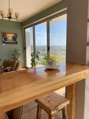 a wooden table with a cup of coffee on top of it at Glass house in Ulcinj