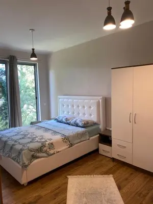 a bedroom with a large bed and a white cabinet at Glass house in Ulcinj