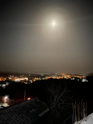 a moon in the sky over a city at night at Glass house in Ulcinj