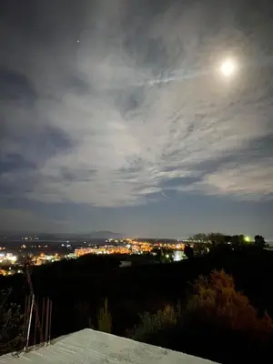 a view of a city at night with the moon at Glass house in Ulcinj