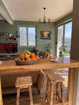 a kitchen with a table with a bowl of fruit at Glass house in Ulcinj