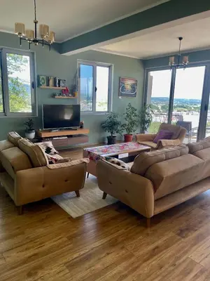 a living room with two couches and a tv at Glass house in Ulcinj