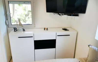a white cabinet with a television on top of it at Awesome Apartment In Utjeha With Wifi in Utjeha