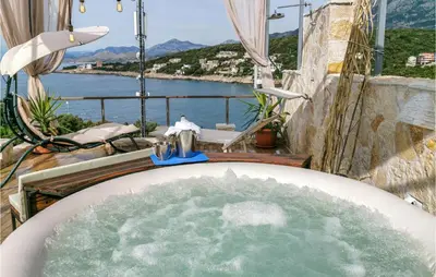 a bath tub with water in it on a balcony at Awesome Apartment In Utjeha With Wifi in Utjeha